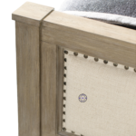 Close-up of the Banjara Hill Panel Bed’s upholstered headboard with nailhead trim and oak wood frame in Earth finish.