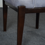 Close-up of wooden legs of upholstered dining chair with polished finish