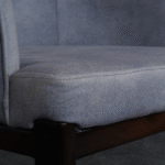 Close-up left side of fabric dining chair with stitching and cushioned seat