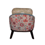 Back view of floral upholstered lounge chair with wooden legs and cushioned backrest